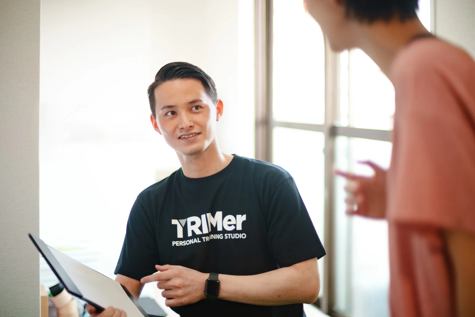 お客様の話を笑顔で聞くTRIMerのトレーナー